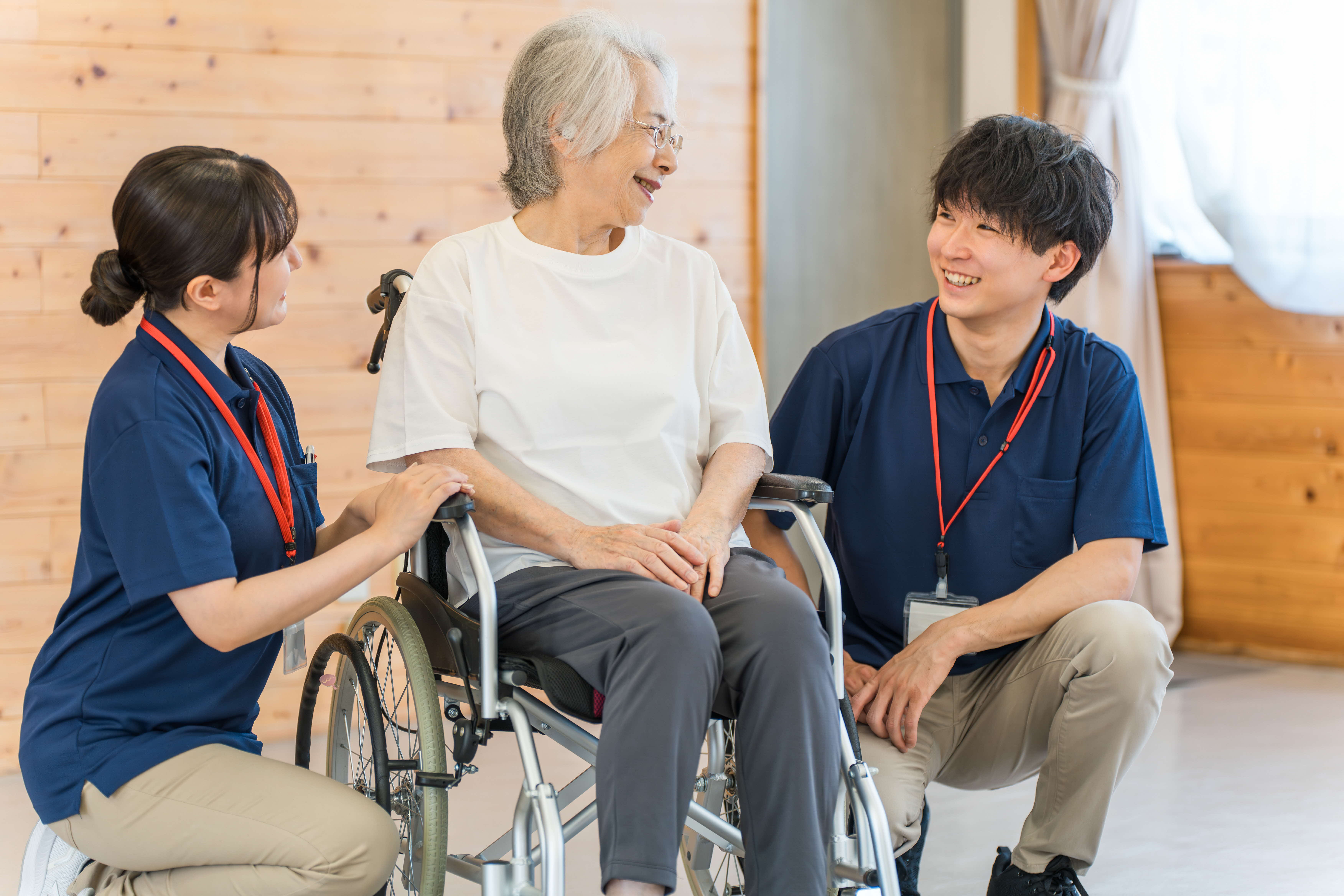 介護職員が車いすの高齢者と談笑する様子